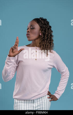 African woman making pistol gesture from her hands and shooting Stock Photo