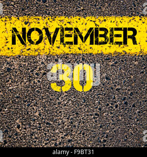 30 November calendar day written over road marking yellow paint line Stock Photo