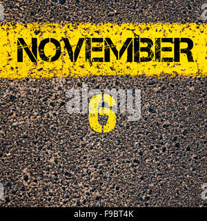 6 November calendar day written over road marking yellow paint line Stock Photo