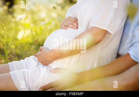 Close up of human hands holding pregnant belly Stock Photo