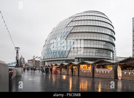 London Bridge City Christmas Market, Southwark, London SE1, on a wet day with City Hall in the background Stock Photo
