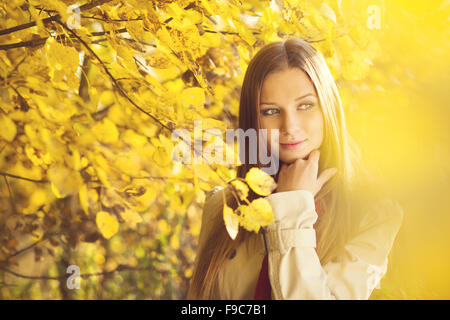 Portrait of beautiful girl in autumn park with yellow leaves Stock Photo