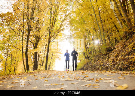 Young running couple jogging in autumn nature Stock Photo