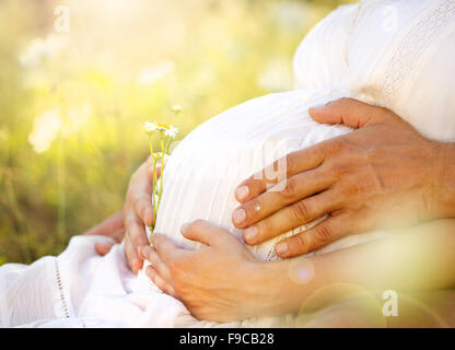 Close up of human hands holding pregnant belly Stock Photo