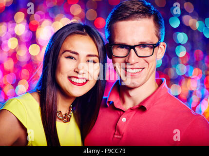Multi-ethnic young couple looking at camera at party Stock Photo