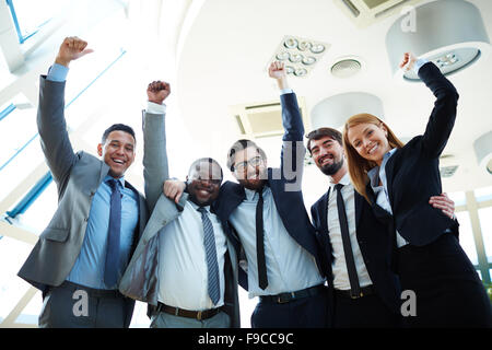 Business team with arms raised and smiling Stock Photo