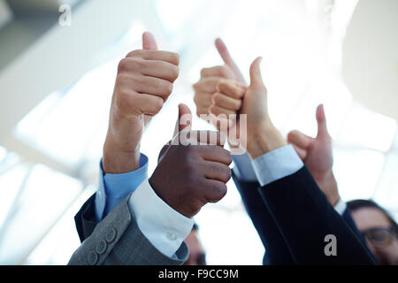 Close-up of business team holding their thumbs up Stock Photo