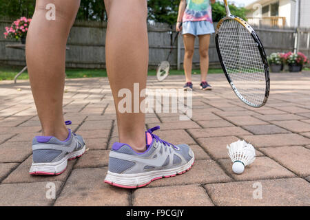 two girls playing  badminton in their backyard Stock Photo