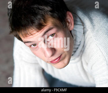 Young man in sweater is looking up. Stock Photo