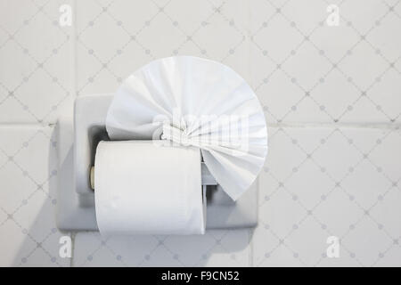 folded toilet paper on the wall with a toilet paper holder Stock Photo