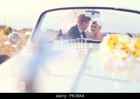 Bride and groom in a vintage car Stock Photo