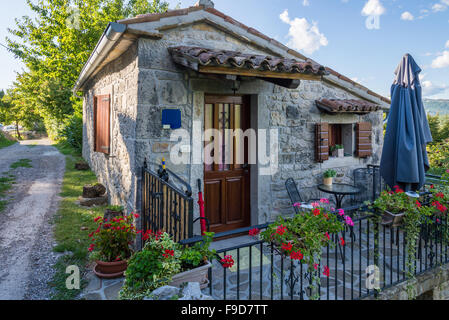 a small stone house with a metal fence Stock Photo