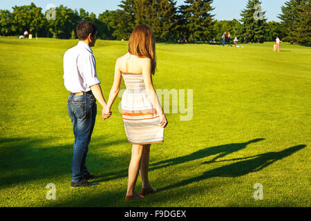 Lovers young man and woman walking in the summer park Stock Photo
