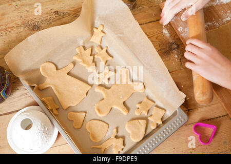 The making of gingerbread is a time honored tradition at Christmas. The gingerbread is cut from the dough and placed on a tray, Stock Photo