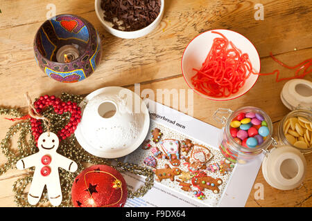 Decorating Gingerbread. A wooden table has the ingredients and recipe for gingerbread men sitting on it. Stock Photo