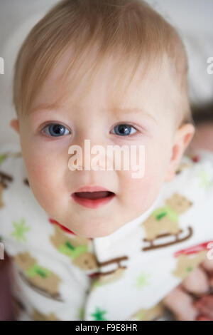 portrait of a blond blue-eyed 10-month old boy wearing a sleeper pj's babygrow Stock Photo