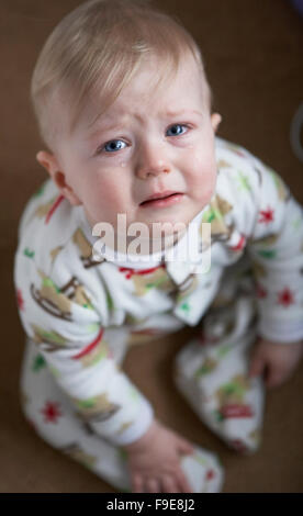 Blonde blond haired sad child crying with tears in his blue eyes Stock Photo