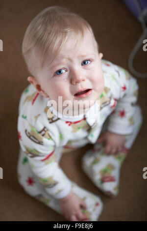 Blonde haired sad child crying with tears in his blue eyes Stock Photo