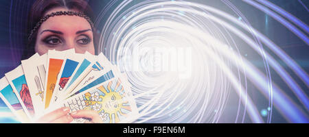 Composite image of fortune teller holding tarot cards while looking away Stock Photo