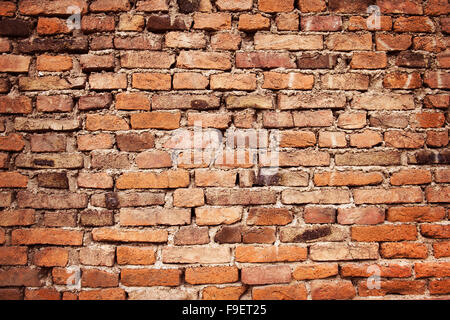 Old empty brick wall background, plaster falling off. Stock Photo