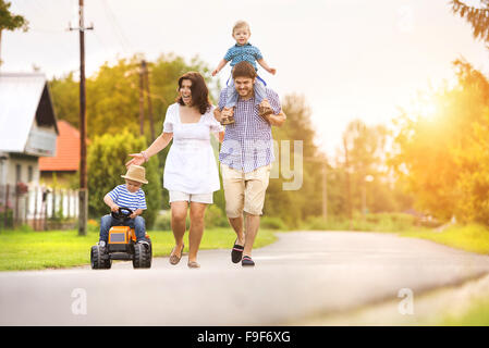 Happy young family having fun outside on the street of a village Stock Photo