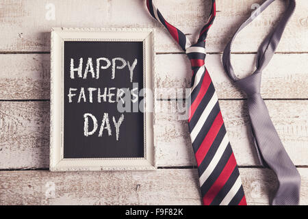 Rectangle picture frame with Happy fathers day sign and two ties laid on wooden floor backround. Stock Photo