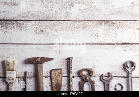 Desk of a carpenter with various tools. Studio shot on a wooden background. Stock Photo