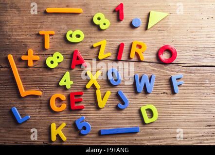 Colorful plastic letters and numbers laid on wooden background. Stock Photo