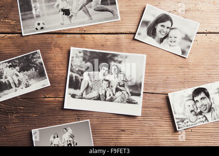 Black and white family photos laid on a table. Studio shot on wooden background. Stock Photo