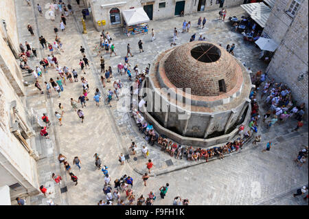 A crowd of tourists gathered around the Onofrio water fountain at the entrance of the fortress in the Old Town, Dubrovnik. Stock Photo