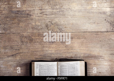 Opened bible on a wooden desk background. Stock Photo