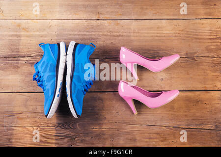 Running shoes and pink court shoes on a wooden floor background Stock ...