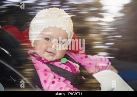 Little baby girl in a car in a child seat Stock Photo