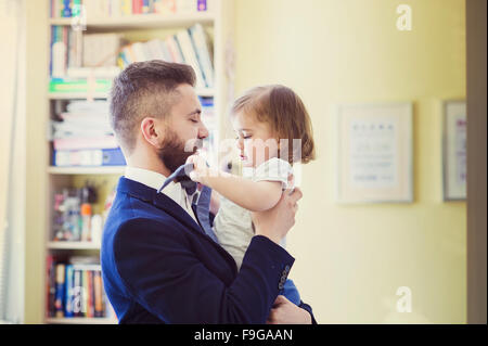 Young father hugging his daughter as he gets home from work Stock Photo