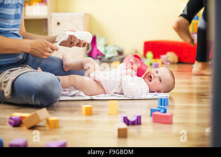 Young hipster father changing nappy to his little baby daughter Stock Photo