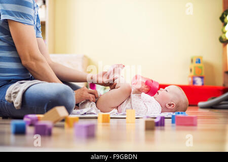 Young hipster father changing nappy to his little baby daughter Stock Photo