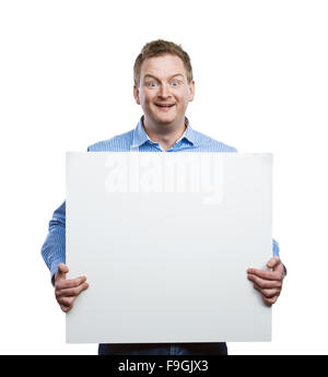 Young man making funny face, holding a blank sign board. Studio shot on white background. Stock Photo