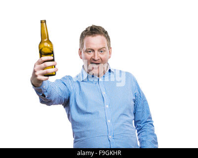 Funny young drunk man holding a beer bottle. Studio shot on white background. Stock Photo