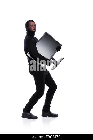 Thief in action stealing information with balaclava on his face, dressed in black. Studio shot on white background. Stock Photo