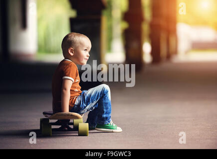 Cute little boy with his skateboard on a walk in the city Stock Photo