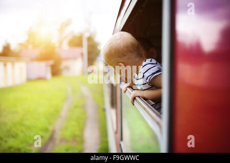Little boy traveling in train looking outside the window. Stock Photo