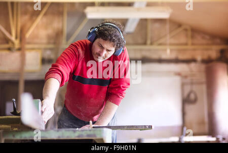 Carpenter working with electric wood planer in his workshop Stock Photo