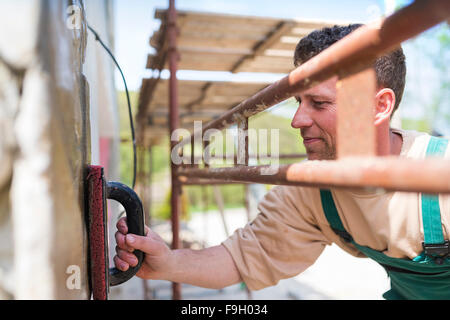 Mason putting decorative natural stones on a wall Stock Photo