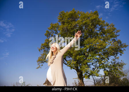 Portrait of beautiful pregnant woman in a field Stock Photo