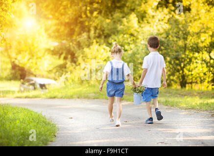 Cute little boy and girl taking a walk outside in nature on a sunny summer day Stock Photo