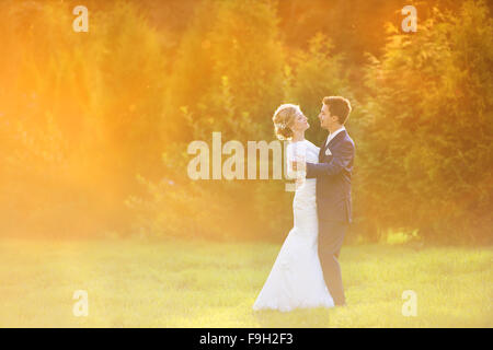 Young wedding couple enjoying romantic moments outside in summer park Stock Photo