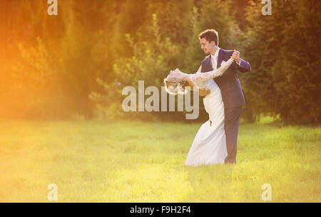 Young wedding couple enjoying romantic moments outside in summer park Stock Photo