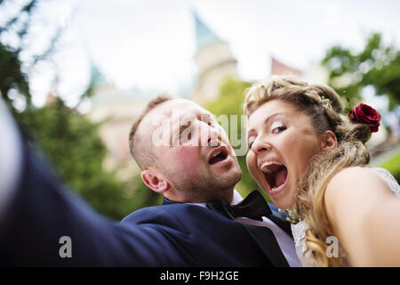Young wedding couple taking a selfie of themselves in front of a castle