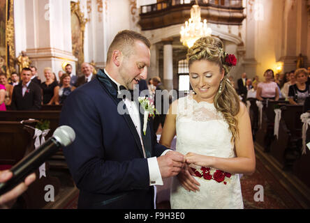 Bride and groom in the church exchanging the rings Stock Photo