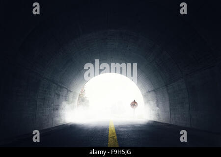 old grunge stop sign in fog and darken tunnel with fog and light at the end of tunnel Stock Photo